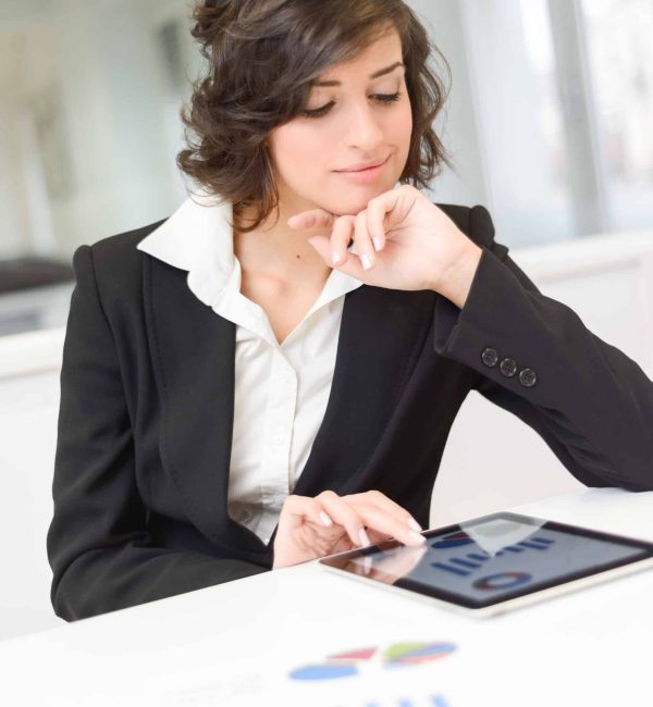 Portrait of young pretty business woman with tablet computer in the office