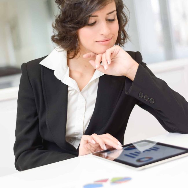 Portrait of young pretty business woman with tablet computer in the office