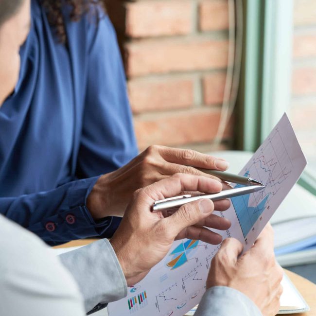 Close-up image of colleagues analyzing information in business document