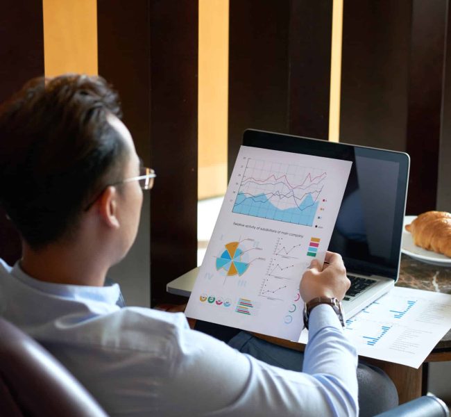 Entrepreneur looking at document with diagram in his hand